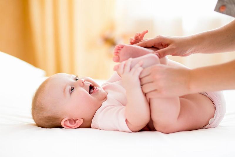 Một em bé đang nằm chơi đùa, mặc bỉm nội địa Trung và trông rất thoải mái, an toàn