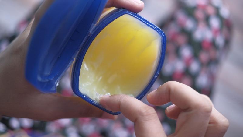 Hình ảnh bàn tay khô nứt nẻ được thoa Vaseline thể hiện công dụng của vaseline dưỡng ẩm