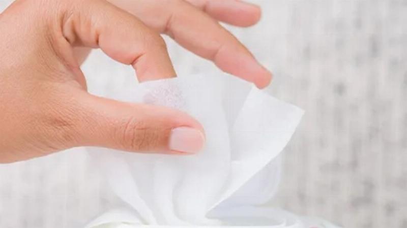 Người phụ nữ đang sử dụng khăn khô đa năng mềm mại để lau mặt sau khi tẩy trang, thể hiện sự tiện lợi và vệ sinh trong chăm sóc da hàng ngày