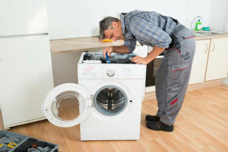 Một người phụ nữ Việt Nam đang mỉm cười ngửi quần áo thơm mát sau khi giặt bằng nước giặt Thái Lan, phông nền là ban công đầy nắng.