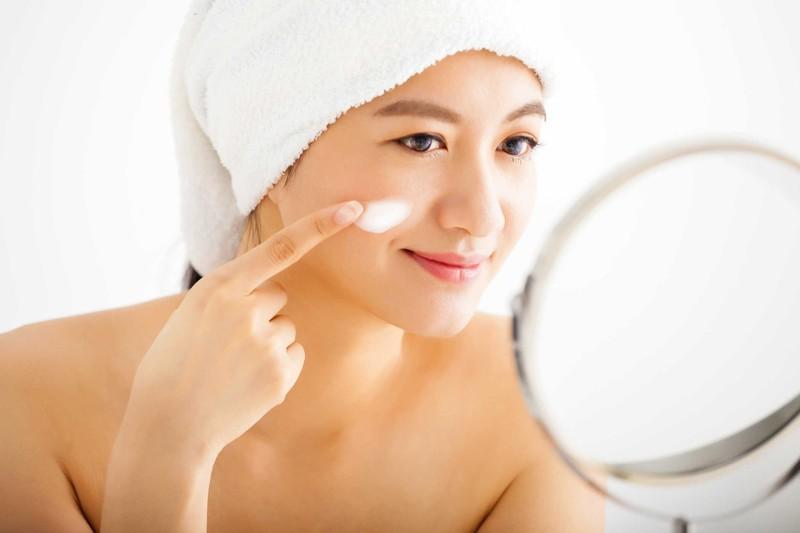 Một người đàn ông trẻ đang sử dụng sản phẩm tẩy da chết cho da mặt