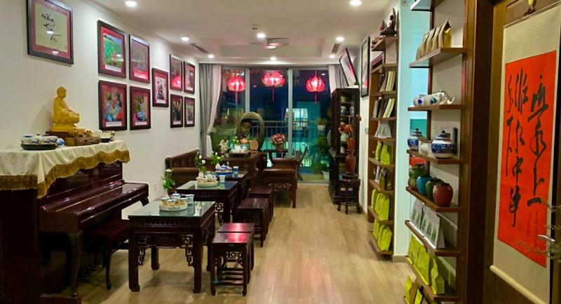 Một cảnh người đang ngồi thư thái trong quán hoặc tại nhà, nhâm nhi ly hồng trà từ hồng trà ngô gia menu