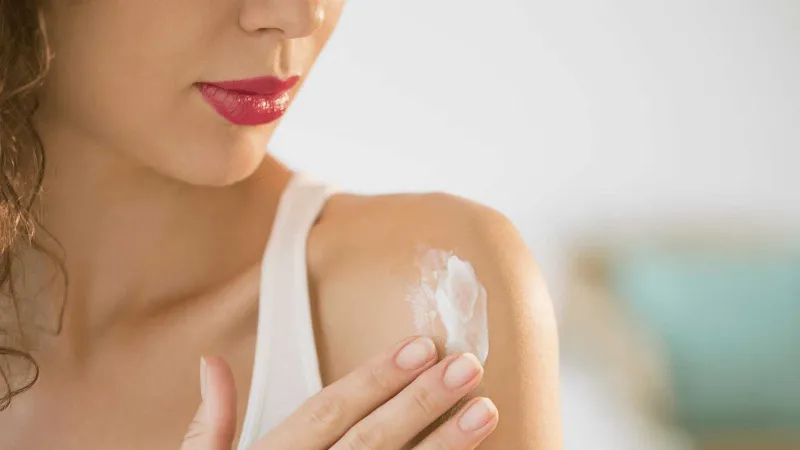 Hình ảnh người phụ nữ thoa Vaseline lên chân sau khi tắm, minh họa công dụng của vaseline dưỡng ẩm body